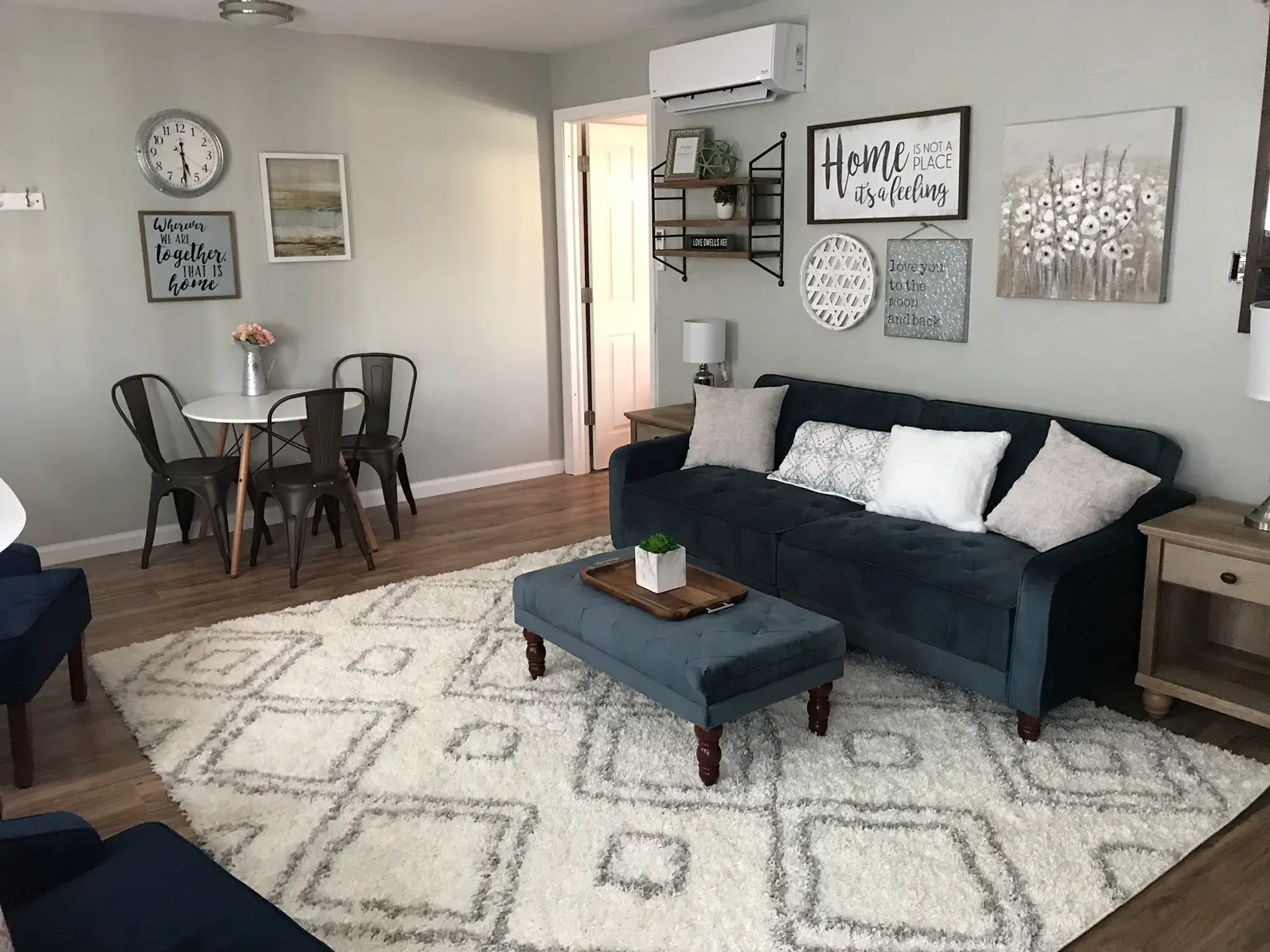 A living room Meghan styled, with a tufted navy sofa and a gallery wall