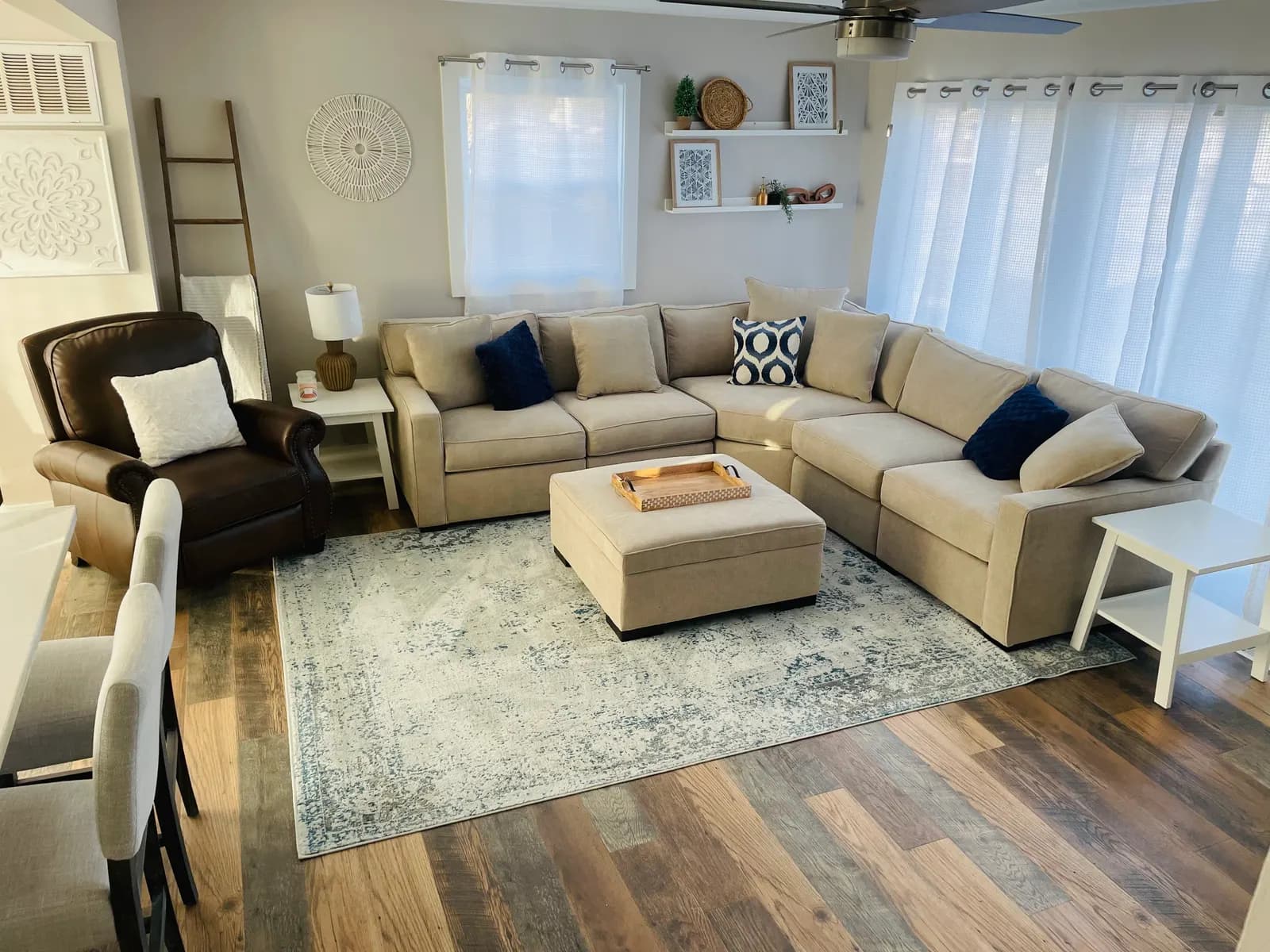 Open living room of the bayside house, in soft neutrals with navy pillows