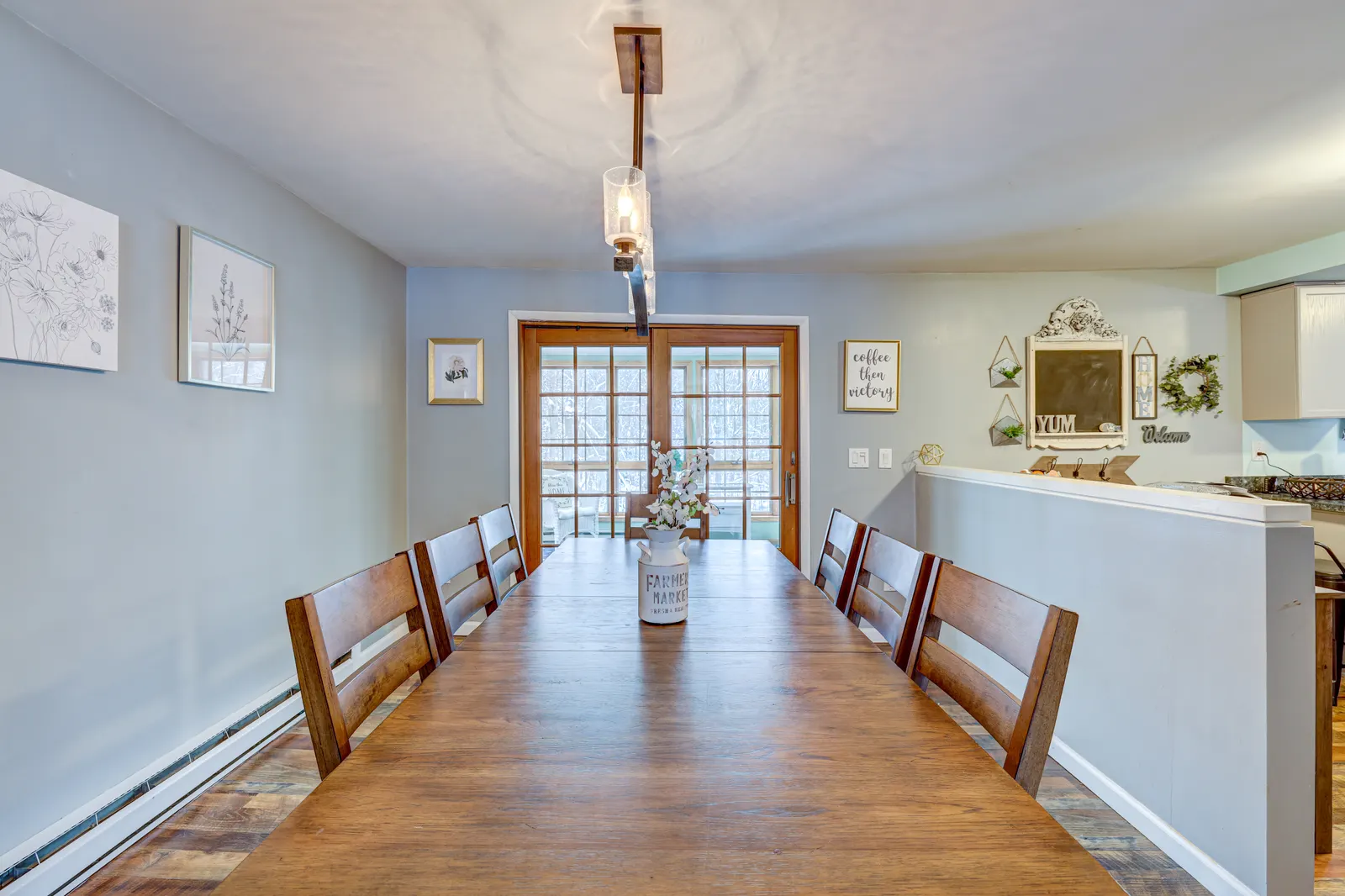 Long farmhouse dining table beneath a pendant light
