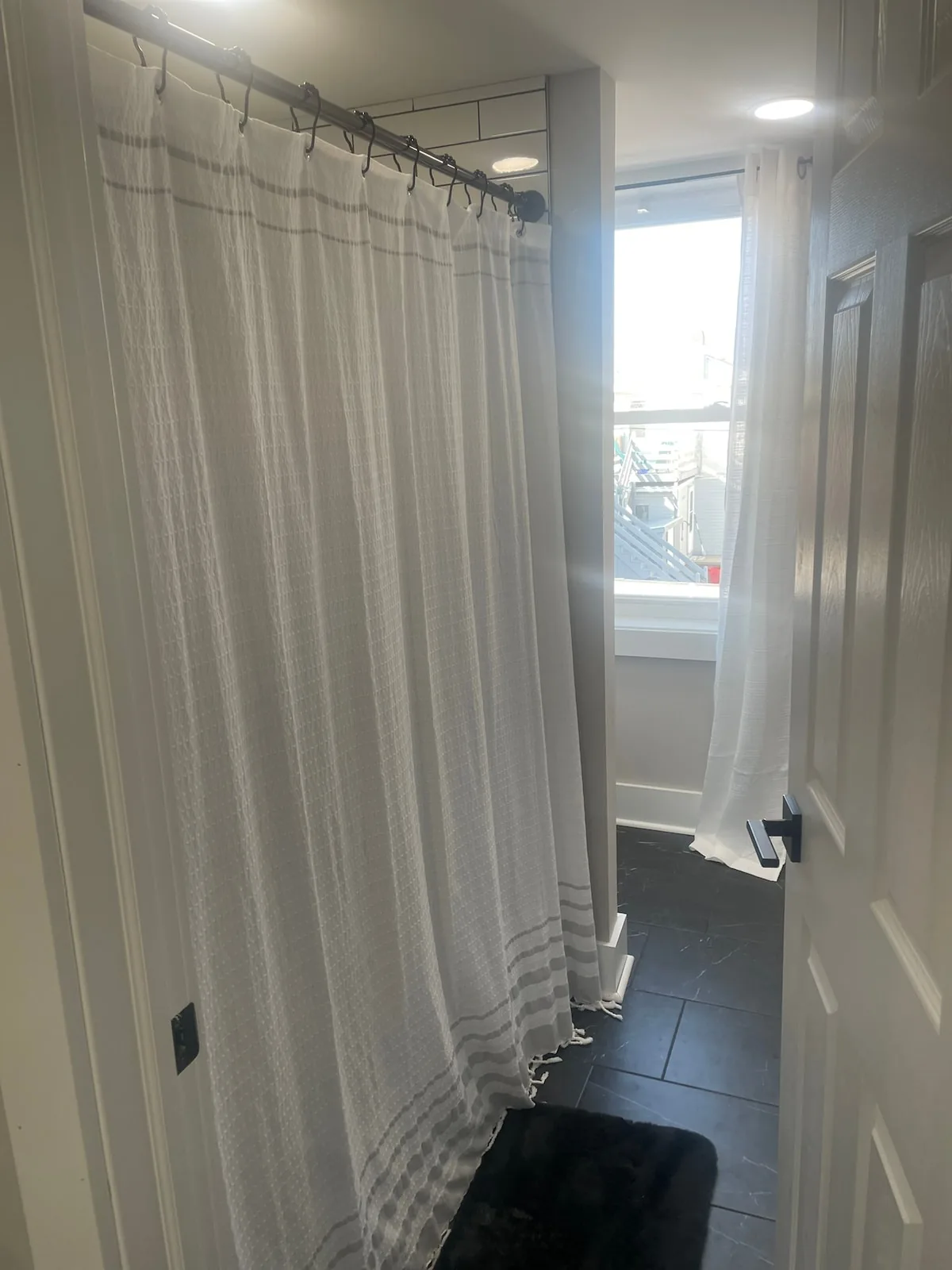 Bright full bathroom with tiled shower and natural light