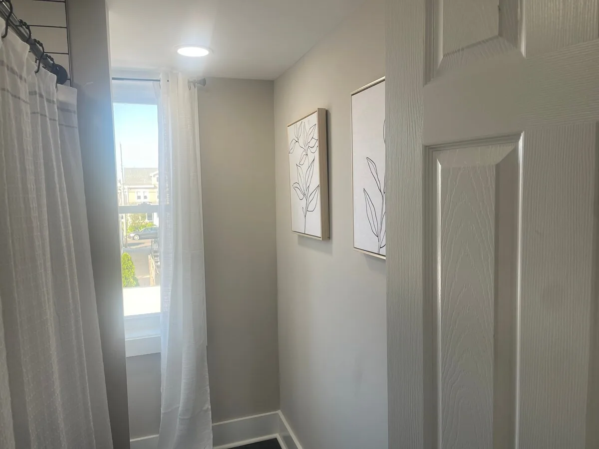 Full bathroom with shower and softly filtered window light