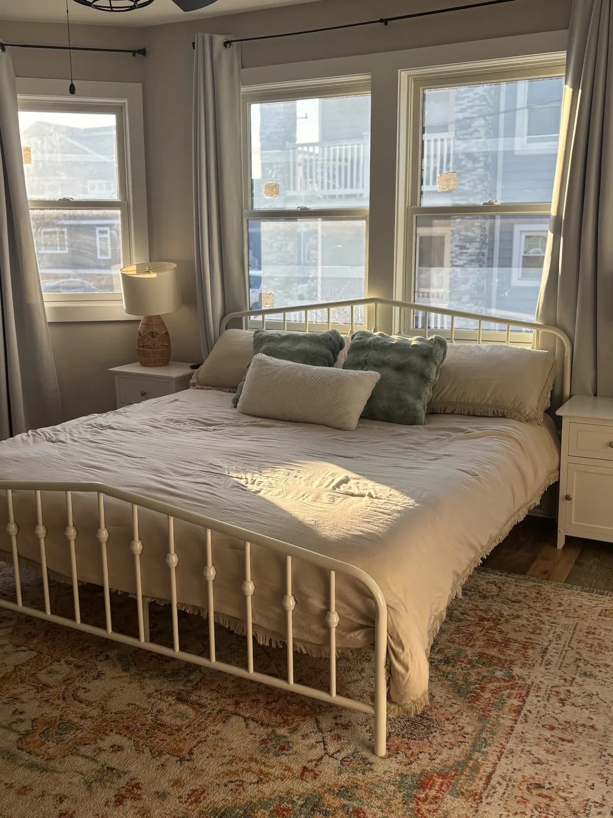 Guest bedroom with metal bed frame and corner windows
