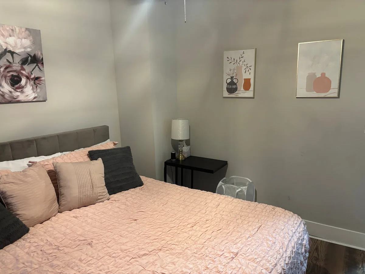 Playful guest bedroom with blush bedding and cat artwork