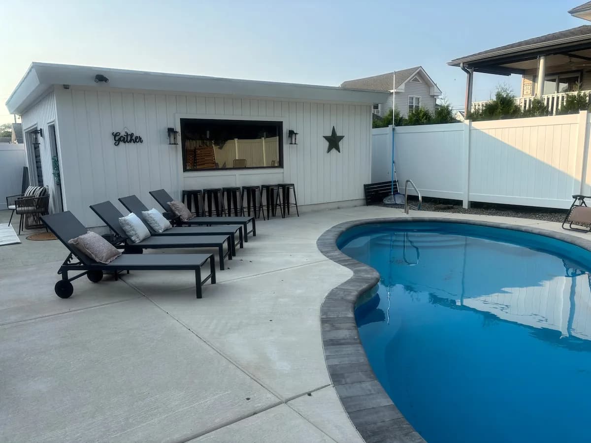 Private pool and sun loungers in the fenced backyard
