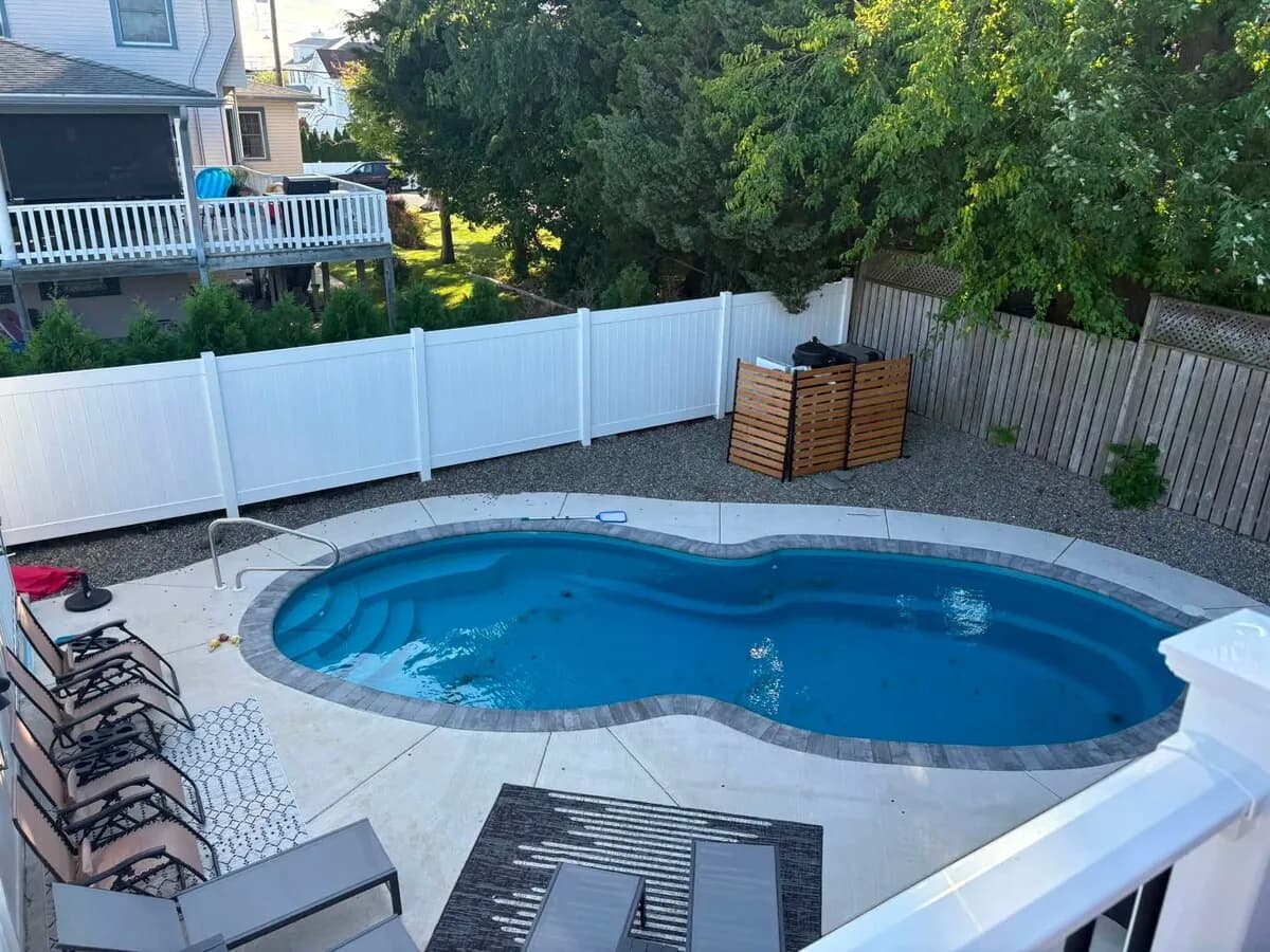 Private backyard pool framed by lounge chairs