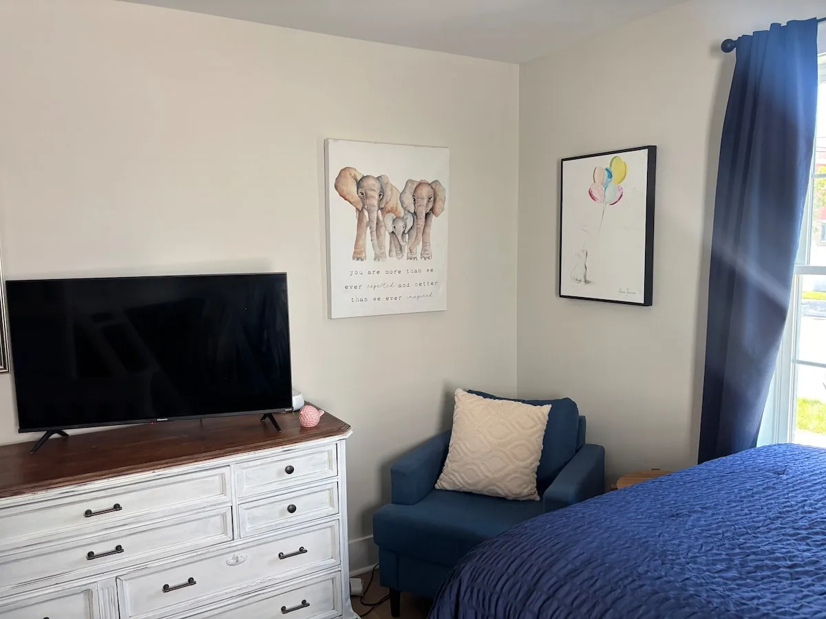 Bedroom with twin bed, television, and blackout curtains