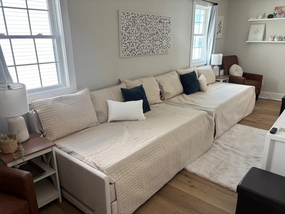 Sunlit bedroom with a daybed and layered pillows