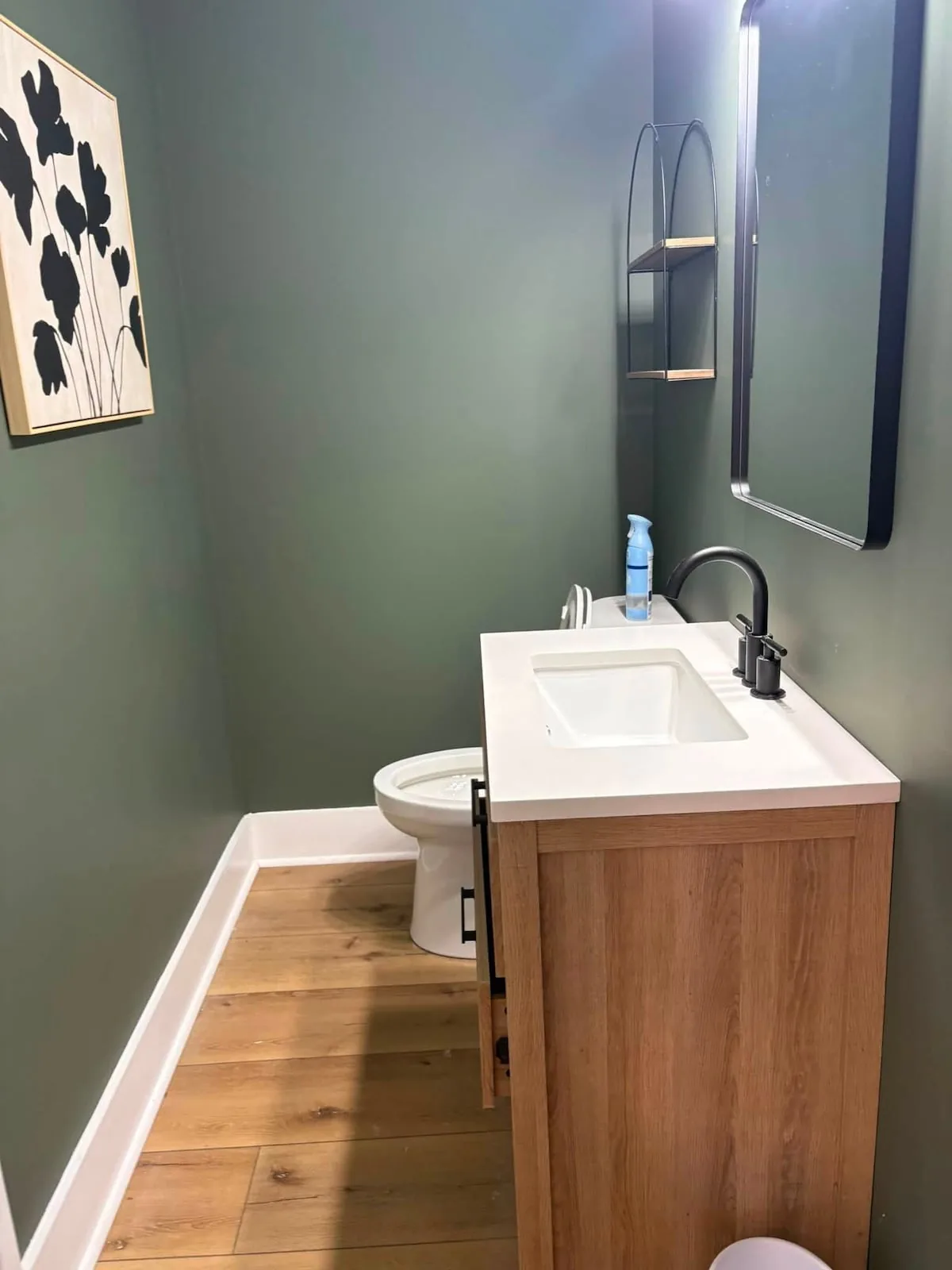 Compact green bathroom with a modern vanity