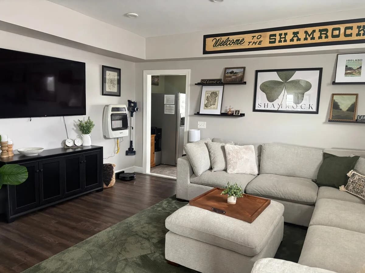 Finished Shamrock gathering room with a generous sectional and historic wall display