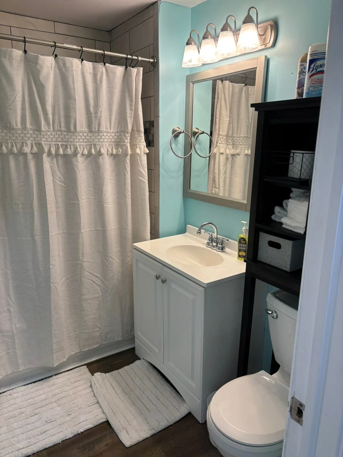 Full bathroom with storage and a bright vanity